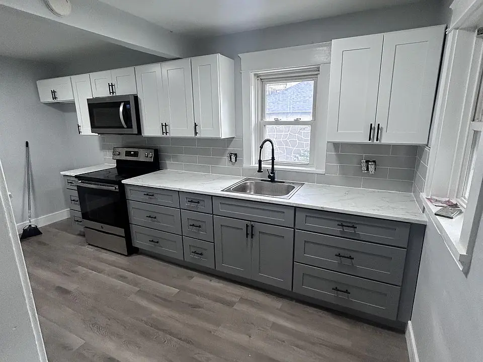 Two-tone white and grey galley kitchen with black hardware