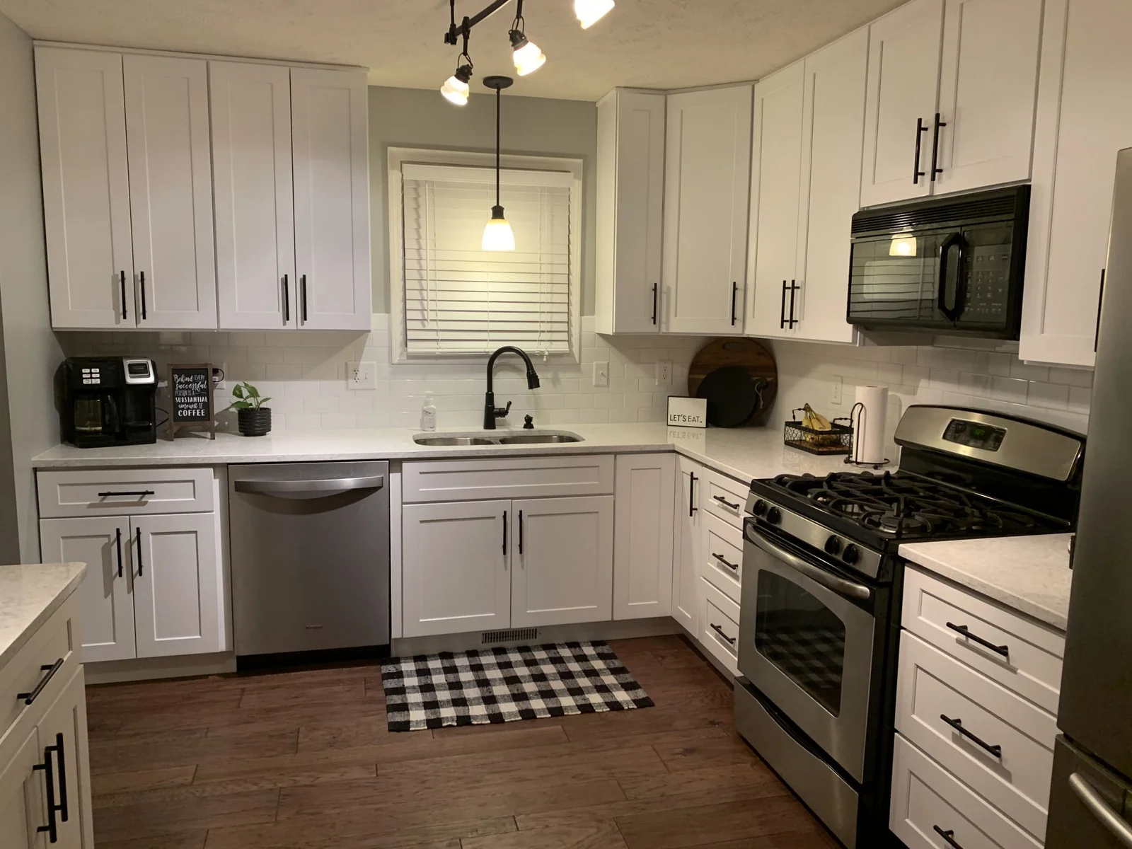 Crisp white shaker kitchen with black handles and subway tile backsplash