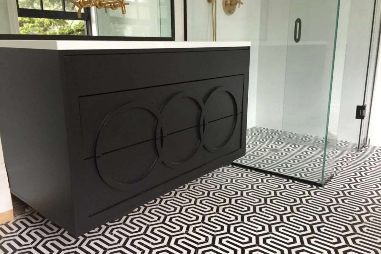 Matte black bathroom vanity with white quartz top and patterned tile