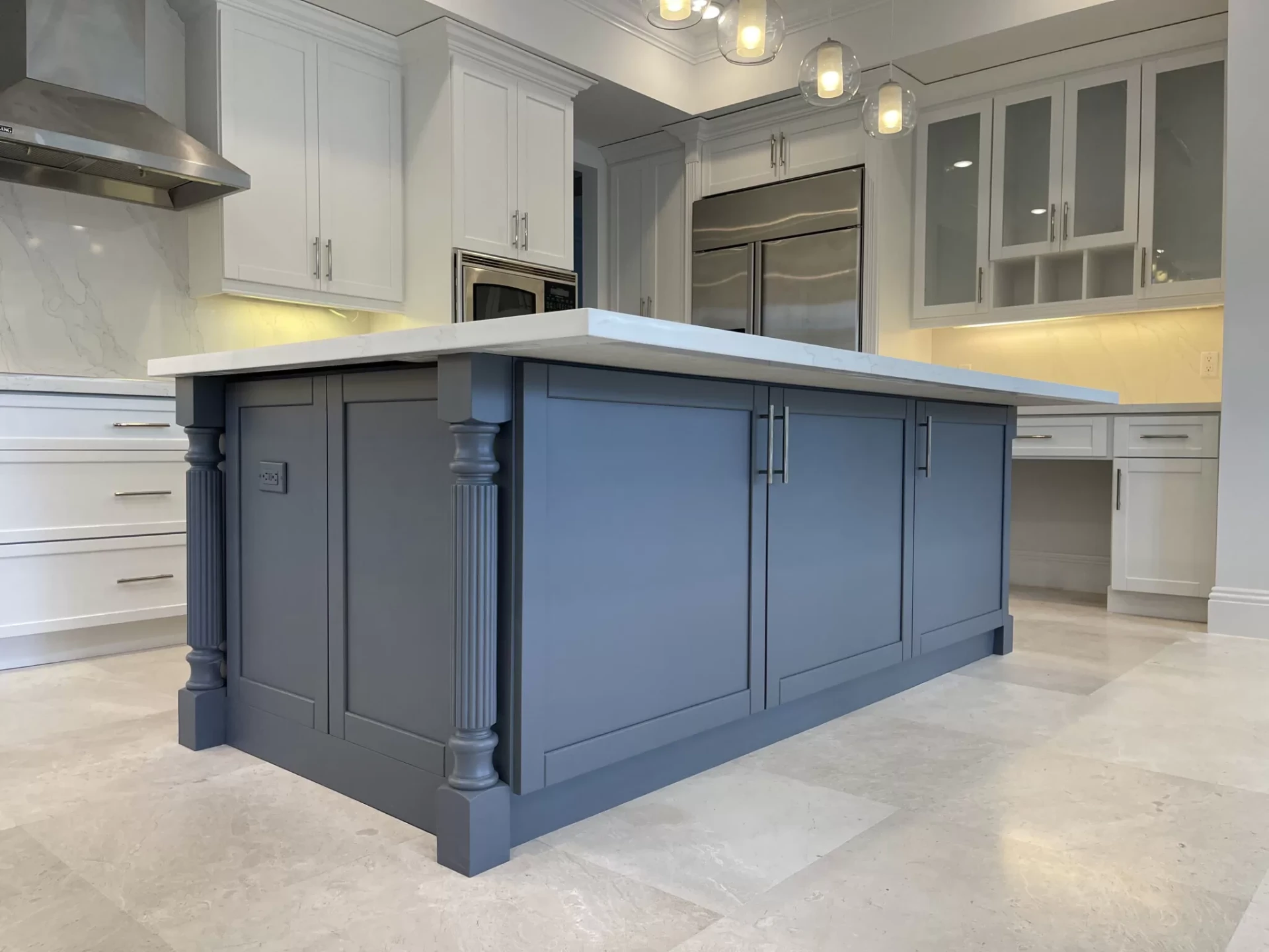 Slate blue kitchen island with white quartz top and white perimeter cabinets
