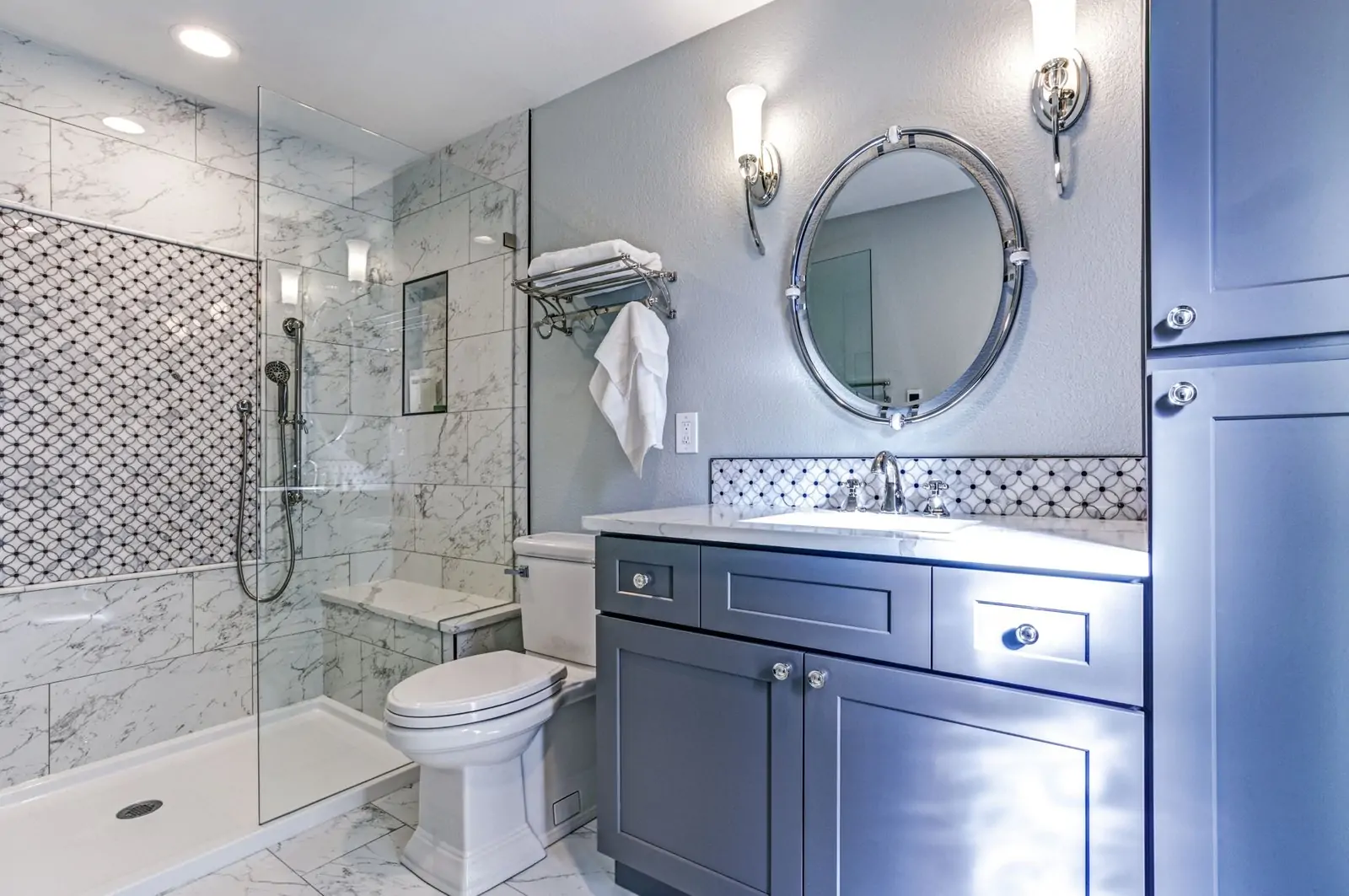 Blue-grey bathroom vanity with chrome fixtures and marble tile