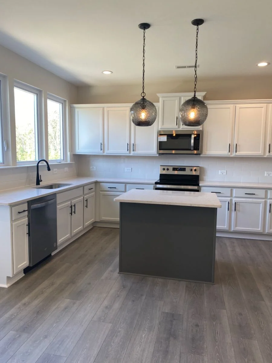 White shaker kitchen with charcoal island and smoked glass pendant lights