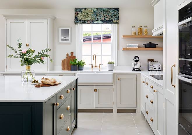 Classic off-white shaker kitchen with brass hardware and farmhouse sink